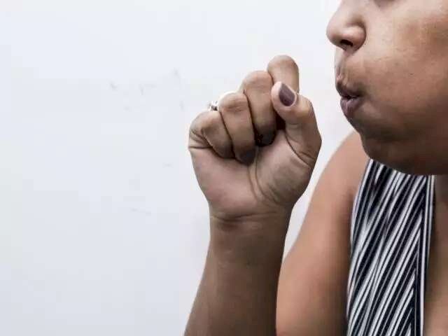 Mulher tossindo com a mão sob a boca. (Foto: Kísie Ainoã)