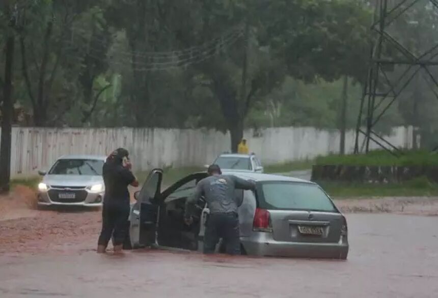 Motorista e passageira do Palio atolado na Guaicurus. (Foto: Marcos Maluf) - CREDITO: CAMPO GRANDE NEWS