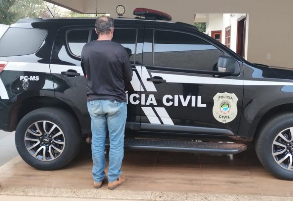 Suspeito do crime diante de viatura da Polícia Civil. (Foto: Polícia Civil)