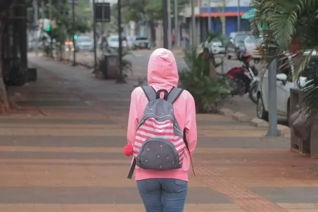 Jovem caminha pelo Centro de Campo Grande vestida com um casado de moletom (Foto: Marcos Maluf)