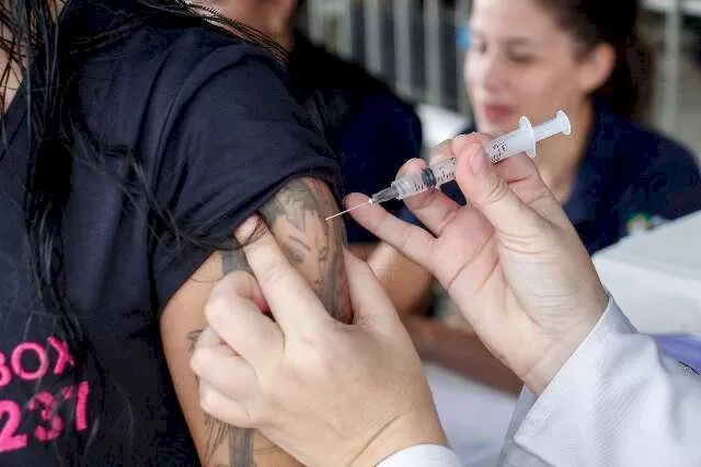 Jovem é vacinado contra a inflenza no Camelódromo da Capital, onde trabalha (Foto: Juliano Almeida/Arquivo)