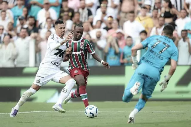 Jogadores disputam a posse da bola no gramado da Vila Belmiro. (Foto: Marcelo Gonçalves/Fluminense)