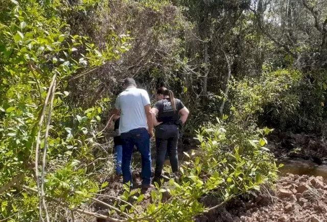 Peritos analisam o local onde ossada foi encontrada. (Foto: Reprodução/Polícia Civil)