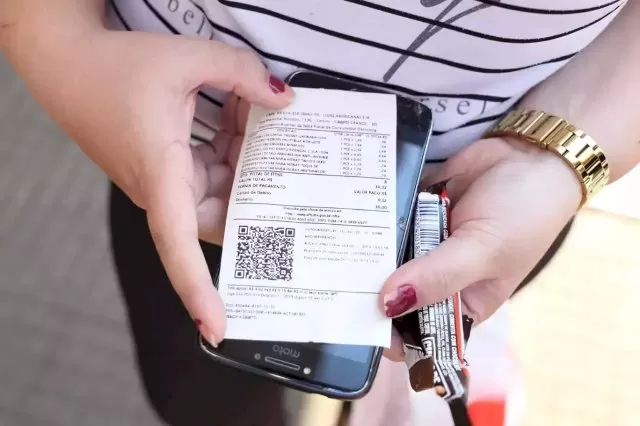 Consumidora segura nota de supermercado. (Foto: Arquivo/Paulo Francis)