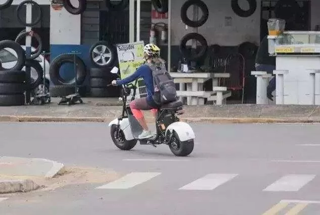 Mulher pilotando ciclomotor em Campo Grande (Foto: Marcos Maluf)